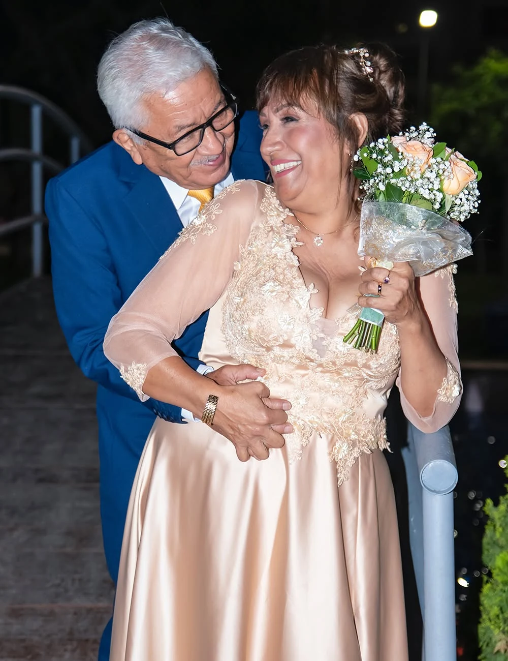 Pareja de esposos celebrando juntos con un ramo de flores