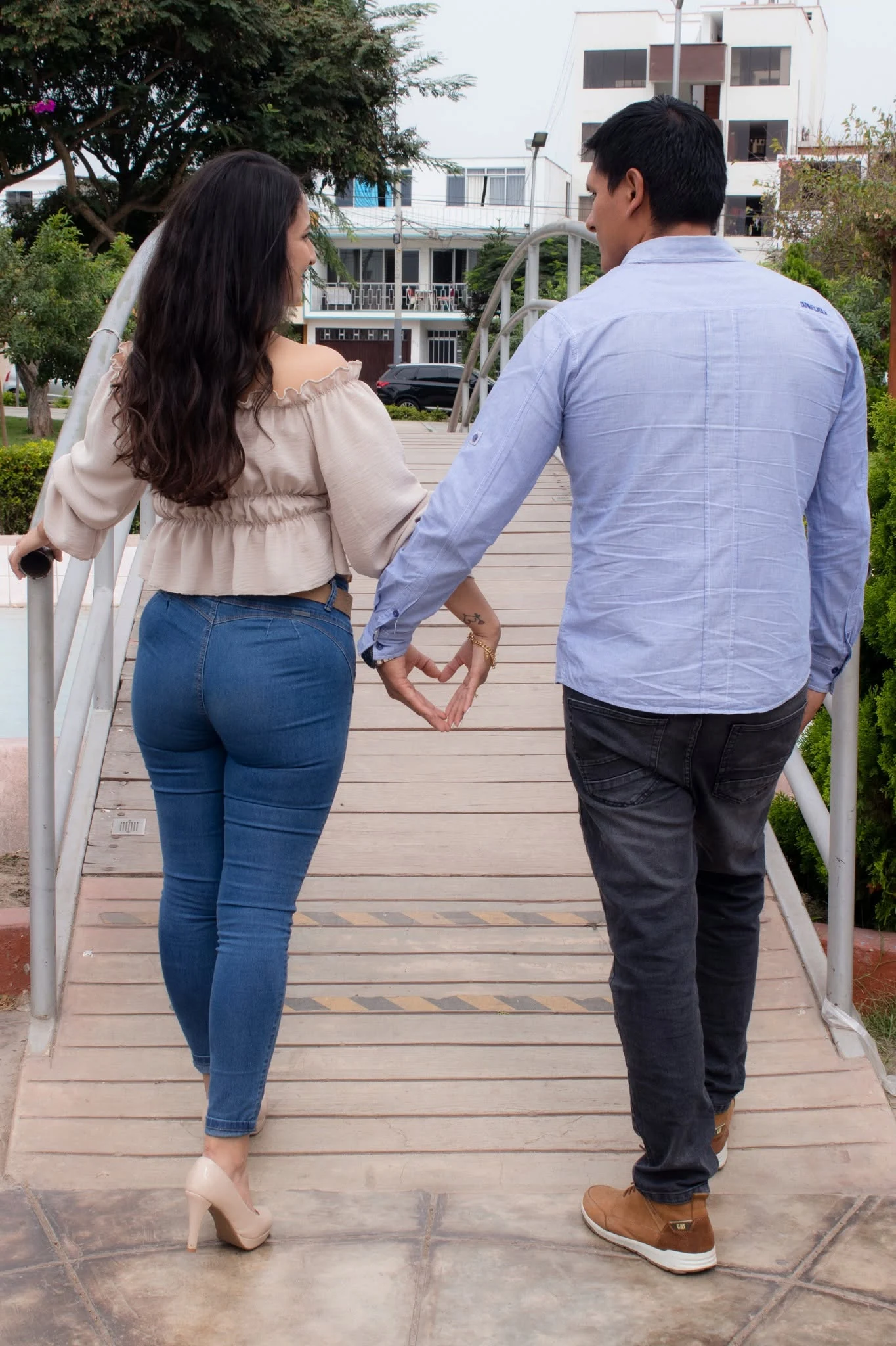 Pareja caminando de la mano sobre un puente