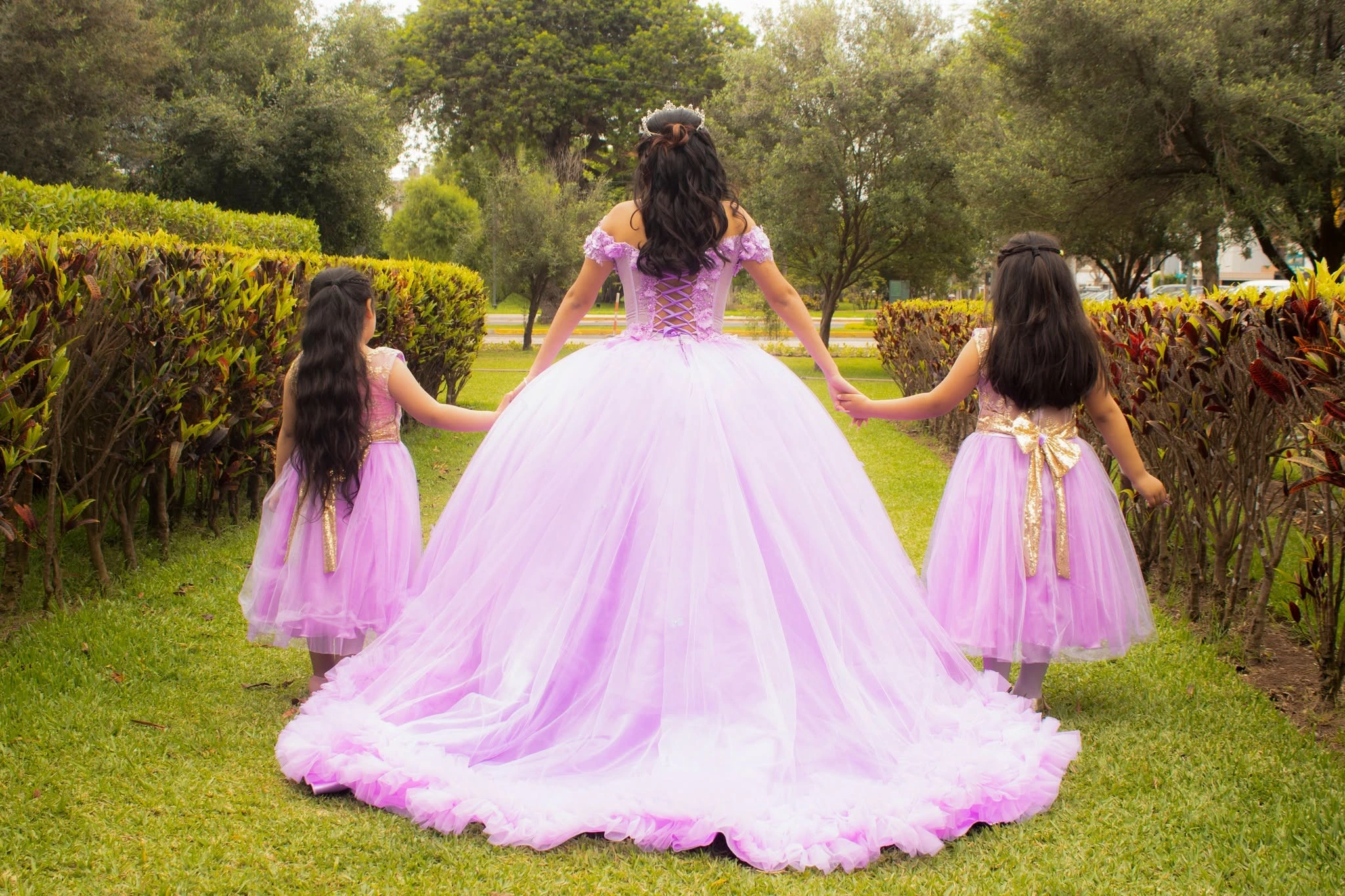 Quinceañera de vestido rosa acompañada de dos niñas